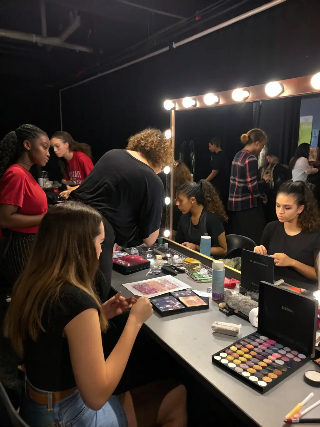 A group of students participating in a makeup course, learning techniques from a professional makeup artist, for Studio Wizażu Glow's website.